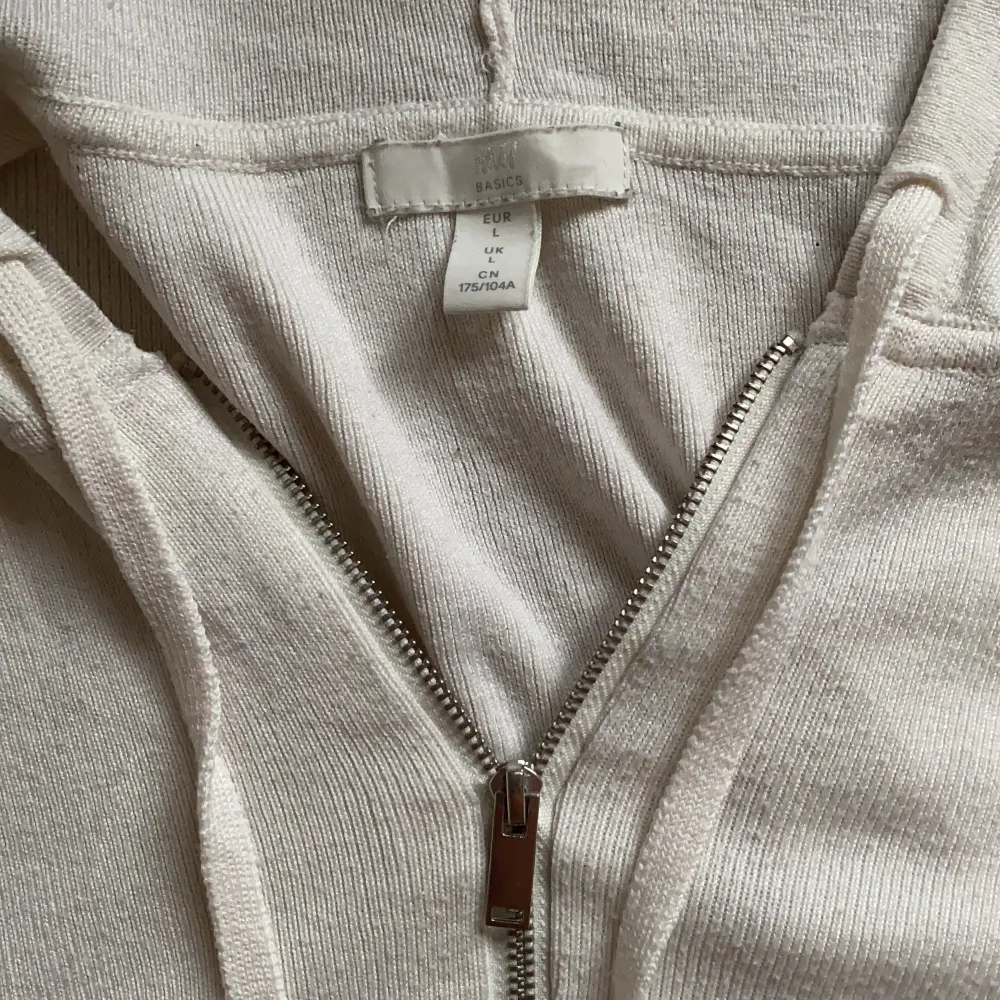 Vit stickad zip-up hoodie ifrån hm i storlek L. Första bilden lånad, resterande är mina. Har en liten missfärgning vid fickan men inget som stör. Skriv privat vid fler frågor! Många intresserade -> budgivning 🐰💓. Hoodies.