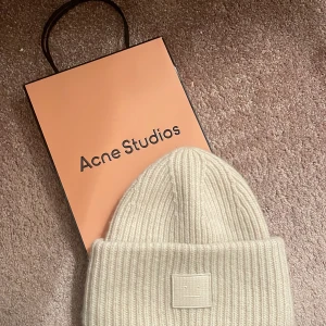 Acne studios  - INTRESSEKOLL på min fina vita/beigea acne studios mössa, använt 2 gånger alltså i nyskick. Köpt på acne studios butik i Paris, nypris 1300. Kom med bud! 