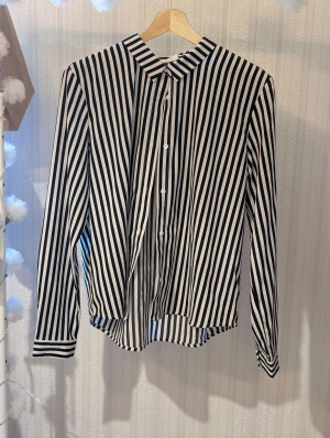 Skjorta  - Säljer den här snygga skjortan då den är för liten, skulle säga att den motsvarar en stor XS eller en liten S. Den har en lite speciell rygg men det är bara snyggt. Skickar inte kan bara mötas upp.