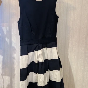 Fest klänning  - Säljer den här klänningen som jag köpte på loppis då den aldrig används. Den har ett utskuret hål på ryggen och ett band med en liten rosett 🎀 Skickar inte kan bara mötas upp.