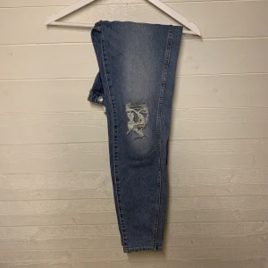 Högmidjade byxor med hål - Fina jeans med smalare passform och hål för knäna. Relativt långa ben med en högmidjad kant. Använda men i väldigt fint skick!  Storlek M men skule säga att dem passar s bättre!