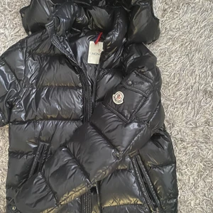 Moncler maya - Säljer min moncler maya för 2 lax, den är äkta såklart har legit checkat o sånt. Nåra små hål men dom syns knappt, och hängkroken är trasig (går såklart att laga) därför säljer jag den för det priset. Vid snabb affär kan priset diskuteras