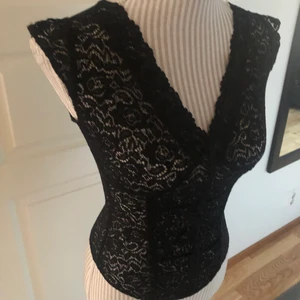 Spets top med korsett detalj strl xs/s - Har hittat i min mammas förråd av kläder hon köpte för 15 år sedan för att återsälja (och alltså oanvänd och i bra skick). Liten storlek men lite stretchig. *Köparen står för frakten*