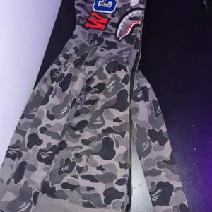 bape hoodie grey camo - Äkta bape hoodie köpt på officiel bape butik i japan. Ganska använd trasig vid ärmarna och solblekt innuti luvan