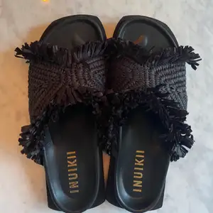 Säljer nästintill oanvända Inuikii-tofflor i storlek 37, svarta. Modellen heter raffia moon sandal. Nypris 2650kr, jag säljer för 1400kr