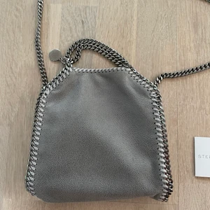 Stella McCartney falabella tiny tote  - Säljer min underbara stella falabella tiny tote! Den är använd fåtal gånger, alltså i nyskick!  Beställdes från Stella McCartneys hemsida förra sommaren så kvitto finns på mail och kan vidarebefordras. Dustbag och äktahetsbevis finns även! 💕💕nypris 7240kr