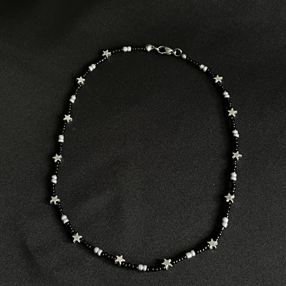 Super fint halsband gjort av svarta och silvriga pärlor blandat med små stjärnor. Halsbandet är mellan 35-40cm. Det ingår spänne och ringödlor så man kan justera halsbandet. Obs frakten kostar 15kr. Accessoarer.