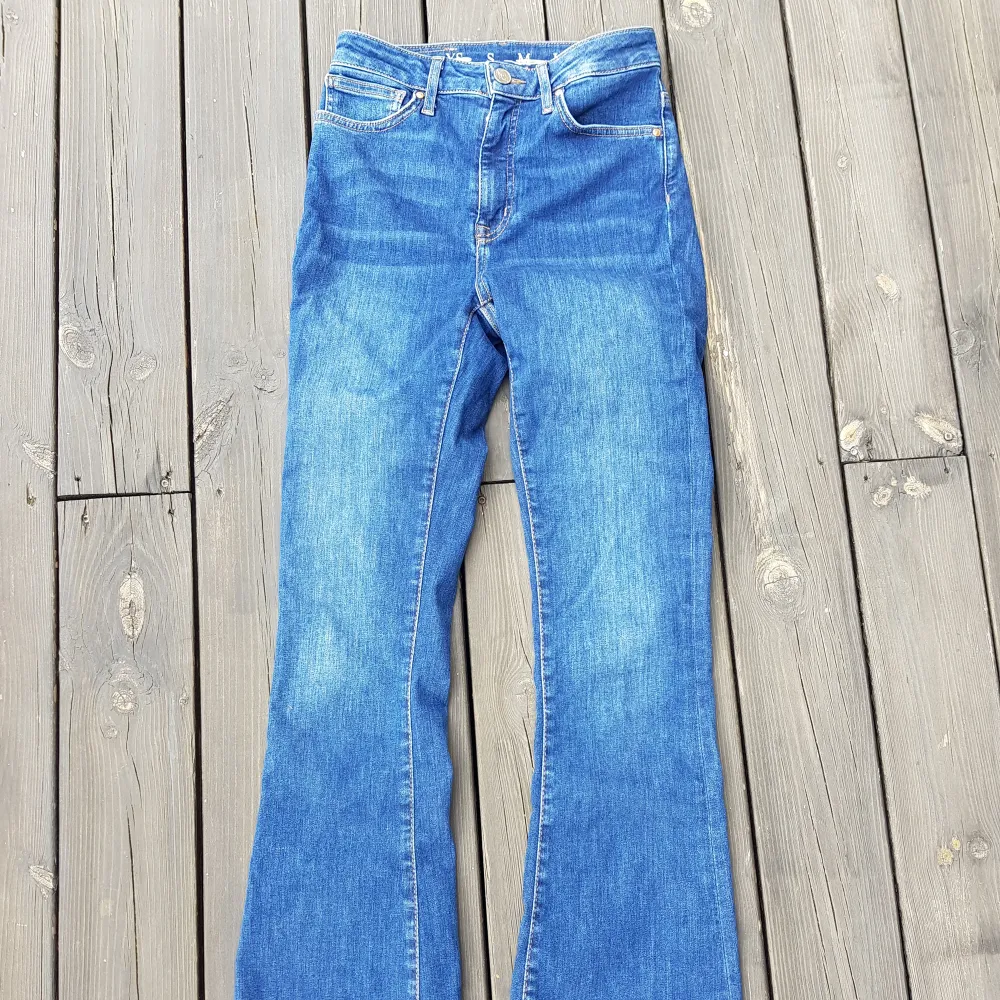 Mörkblå utsvängda jeans i storlek S. Stretchtyg. Hög midja. Knappt använda. Inköpta på Bik Bok, märke Never Denim.. Jeans & Byxor.