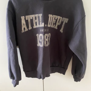 Grå sweatshirt med tryck  - En grå sweatshirt med beigt tryck på framsidan,tröjan är inte använd då den aldrig kommit till användning. Tröjan är oversize i modellen. Tröjan är i xxs men skulle säga att den är som en s då den är oversize. Nypris: 259kr 