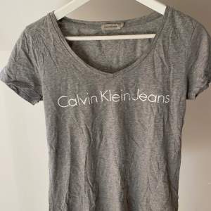 V-ringad t-shirt med tryck från Calvin Klein i storlek m men passar även XS/S om man vill ha en mer oversize fit. Använd väldigt sparsamt så tröjan är i mycket gott skick. Nypris ca 500 kr