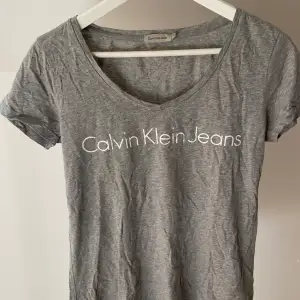 V-ringad t-shirt med tryck från Calvin Klein i storlek m men passar även XS/S om man vill ha en mer oversize fit. Använd väldigt sparsamt så tröjan är i mycket gott skick. Nypris ca 500 kr