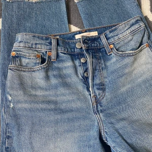  Levi's wedgie straight jeans 27  - Säljer dessa superfina jeans från Levis i storlek 27 vilket motsvarar XS/S. Endast använt ett fåtal gånger. Avklippta ben och hål vid knäna, lite mörkare på baksida (se bild). Medelhög midja.   Se gärna mina andra annonser så kan jag samfrakta :)! 