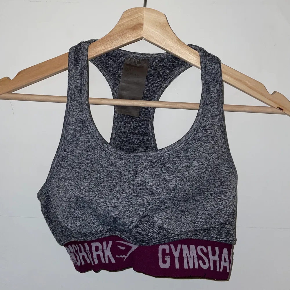 Sport-BH från gymshark i kollektionen Flex, gammal kollektion och färg, charcoal grey deep plum tror jag färgen heter. Storlek S, racerback. Välanvänd men inga synliga slitningar bortsett från lite på resorbandet.. Toppar.