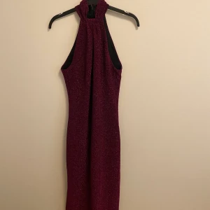 Rosa glittrig balklänning - En rosa glittrig tight balklänning. Klänningen har en detalj i nacken och är som en polokrage och sedan öppen i axlarna och tight ner❤️