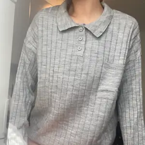 grå ribbstickad långärmad tröja med knappar och krage. använd 1 gång. köpt på asos