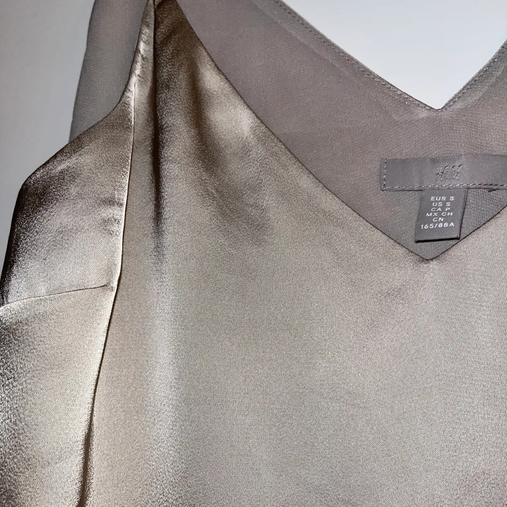 Såå vacker silvrig silkes liknande linne med V-ringning! Säljes pga för stor i storlek😔 Från HM och skulle fler bilder önskas i dagsljus så skicka bara iväg ett Pm så löser vi 😙. Blusar.