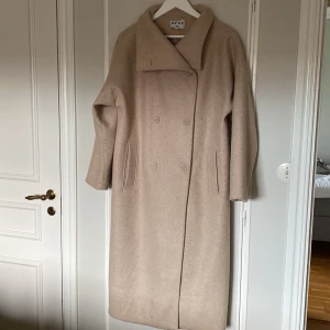 Kappa - Lång kappa, inköpt april -22. Sparsamt använd. Nypris 1100 kr. Beige Märke NA KD