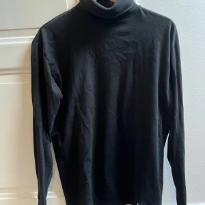 Rumble clothing  - En svart turtleneck som sitter hyfsat tajt på kroppen. Får en bra passform på kroppen. Kondition 9/10