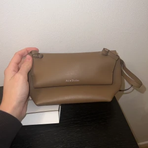 Acne väska - Mini shoulder bag från acne studios. Väskan är i jättefint skick då jag bara använt den en gång och köptes i år så inget tecken på användning finns. Väskans nypris idag är 4600kr, mitt pris 3000kr. Kan gå ner i pris vid snabb affär!⭐️