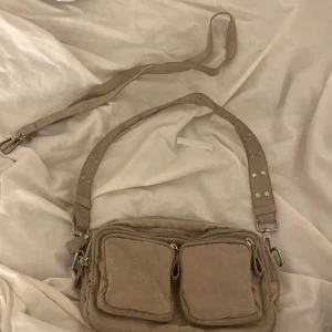 Väska - Säljer en till väska från ginatricot som är exakt lika Dan som den svarta fast beige💗 väskan är aldrig använd och man får med band❤️ 