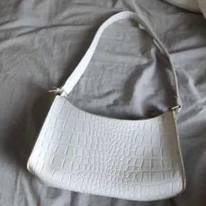 Vit väska - Vit väska från shein. Super fin och i fint skick. Köpte i vintras och han använt den en del, men inte trasig eller så . frakt tillkommer på 20kr direkt till brevlådan!