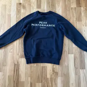 Mörkblå sweatshirt från Peak Performance. Storlek M. Använd men i okej skick, lägre pris p.g.a liten skada i krag. Nypris 900kr