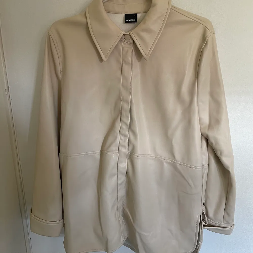 En ljus beige ”läder” skjorta från ginatricot. Köpte den för ungefär 1 år sedan och har knappt använt den. . Skjortor.