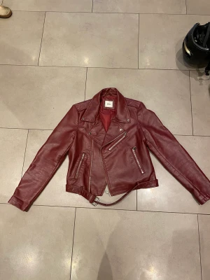 Röd läderjackan  - Supersnygg jacka som är lite för liten för mig. Passar som xs möjligtvis s, ej äkta läder.