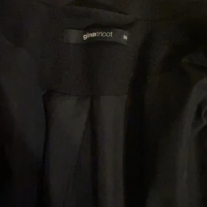 Svart kappa - knälång kappa utan skärp från Gina. Den köptes förra året men har aldrig kommit till användning. Stolek 36. Fler bilder kan såklart fixas. Köparen står för frakten
