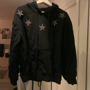 Hoddie - En svart hoddie med brodda stjärnor i silver 