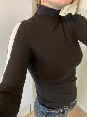 Polotröja med snygg detalj - Skön polotröja med vita ränder på armarna 