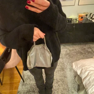Stella McCartney väska  -  Säljer min ljusblå/grå glittriga Stella McCartney väska, självklart äkta. minsta stoleken. Så snygg och lite unikare då den är glittrig. Den har tappat lite färg på handtagen men inget som märks. Nypris ca 7500 kr. 