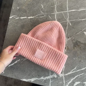 Acne Studios Mössa - En superfin rosa mössa från Acne. Köpt för några år sedan i Acnebutiken! Den har en i princip osynlig fläck som går att tvätta bort om det skulle önskas, annars är den i väldigt fint skick! 