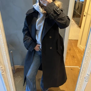 Arket kappa - Säljer denna extremt vackra trenchcoat från ARKET i storlek 34 men oversize så skulle säga att den passar ännu bättre på en 36/38!! Nypris 1800 mitt pris 1000kr då den är som NY!! Jätte fint skick, färg: svart med bruna knappar