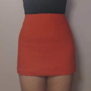 En orange kort kjol. Alldrig använd. Den ser röd ut på vissa av bilderna men den är en klarljus orange färg. Priset står vid 150 + frakt på 39kr 😊