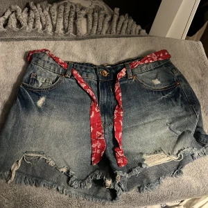 Jeansshorts - Jeansshorts i storlek M från New Yorker. Aldrig använda.  I high waist och dragkedja. Det röda bandet går att knyta runt om och tas enkelt bort om man ej vill ha det. 