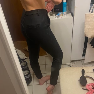 Svarta skinnkostymbyxor - Svarta kostymbyxor i skinn-imitation! Supersköna och fina💞