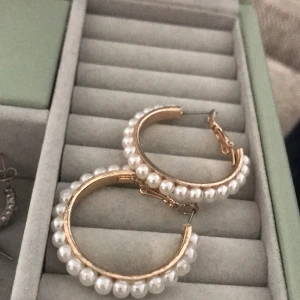 Runda örhängen  - Ett par runda örhängen med vita pärlor runt om. Väldigt fina och bra material. 