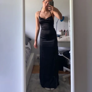 Bal kläning svart - Super vacker och skön balkläning, har slits på ena sidan av klänningen och fin  snörning på ryggen. Perfekt lång för någon som är runt 170-175. Svart silkes aktigt material. Alldrig använd och köpt på Nelly förra året. Priset kan diskuteras💓