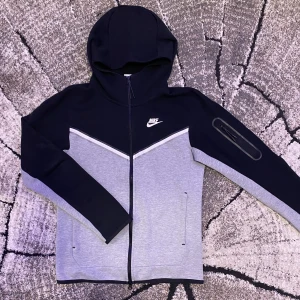 Nike tech fleece huvtröja svart/grå - Säljer min Nike tech fleece tröja då jag bara använt den några gånger och den är som ny. Köparen står för frakten