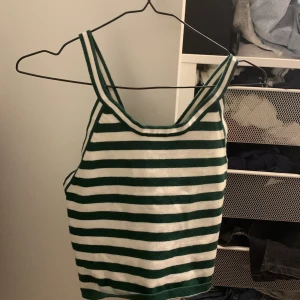 Grönvitt linne - Ett grönvitt randigt linne, med korsande band. Har storleken M och har använts ett antal gånger är nämnd och värde men är i fint skick. Är från shein. Jag står inte för frakten.