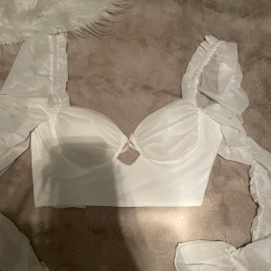 vit topp  - Oh polly inspirerad topp med dragkedja baktill och vadderade kupor. Aldrig använd pga fel storlek. 