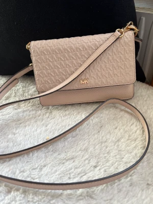 Michael Kors - Liten Michael Kors väska i svag ljusrosa färg. Mycket fint skick