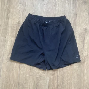 Träningsshorts - Träningsshorts ifrån Soc i storlek S. Jag har använt dom 2 ggr och nu kan jag inte ha dom längre. Det är innebyxa i dom så de är perfekta att sporta i. 