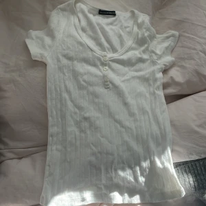 Vit topp! - Säljer min vita topp med knappar då den tyvärr inte kommer till användning! Knappt använd!  Köparen står för frakt