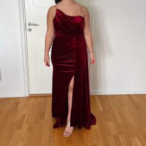 En vinröd sammet klänning som passar perfekt till bröllop och balen. Klänningen är använd endast en gång och är så gott som ny. Den är i storlek M men passar även någon som bär L. Inköpspris: 3000