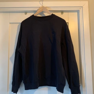 Acne Crewneck (box logo) - Säljer nu min Acne Crewneck med box logo. Den är i fint skick, men lite negativt är att det är små hål längst ut i ärmarna, men är inget man stör sig på! Det är en storlek S men är mer som M.  Pris kan diskuteras vid smidig affär. Nypris 2000! Kan frakta🚚