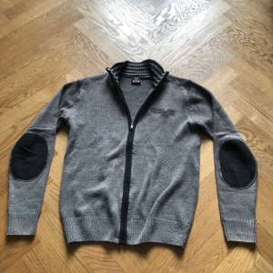 Grå Zip tröja - Jag säljer en mycket fin zip-tröja i grått. Den är använd men inga skador. Nypris: 700. Mitt pris: 300