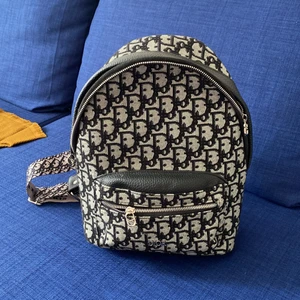 Ryggsäck  - En Dior liknande väska med fina remmar, köpt gör på Plick men använder knappt. Får plats med ett A5 kollegieblock, justerbara remmar . Seriösa köpare, köparen står för frakten. 