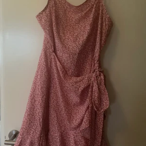 Blommig klänning sommarens måste - Snygg blommig klänning. Aldrig använd pga fel beställning. Omlotlook like. Ett måste i sommar